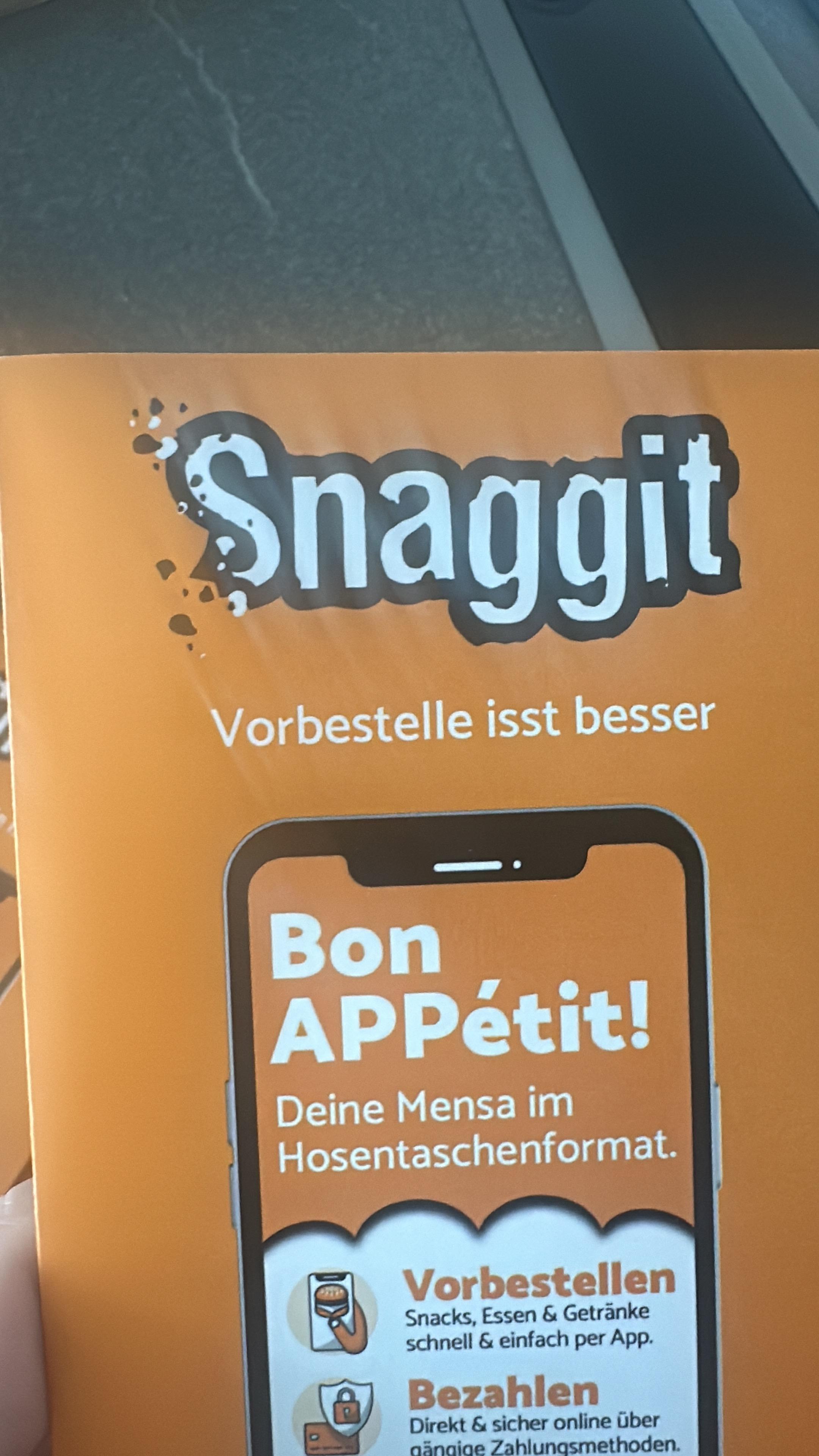 Gedruckter orangefarbener Snaggit-Flyer mit dem Fehldruck Vorbestelle isst besser.